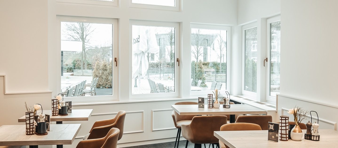 Gemütlicher Gastraum mit moderner Einrichtung und großen Fenstern