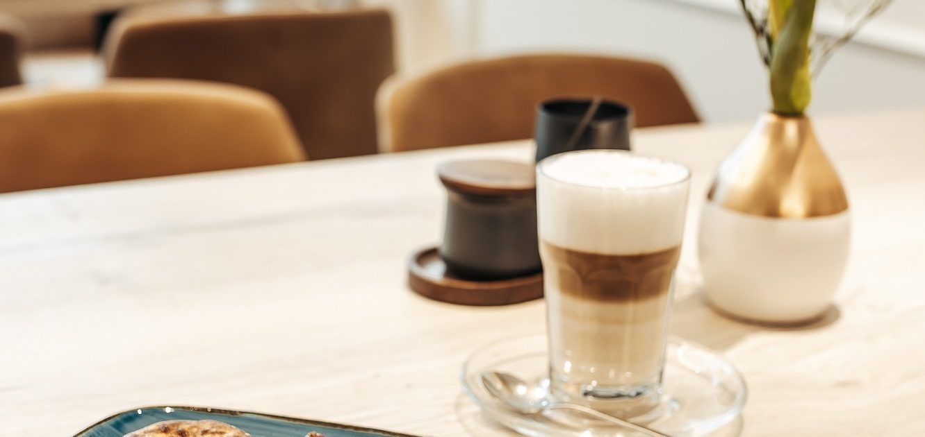 Latte Macchiato mit Gebäck und Beeren im Café