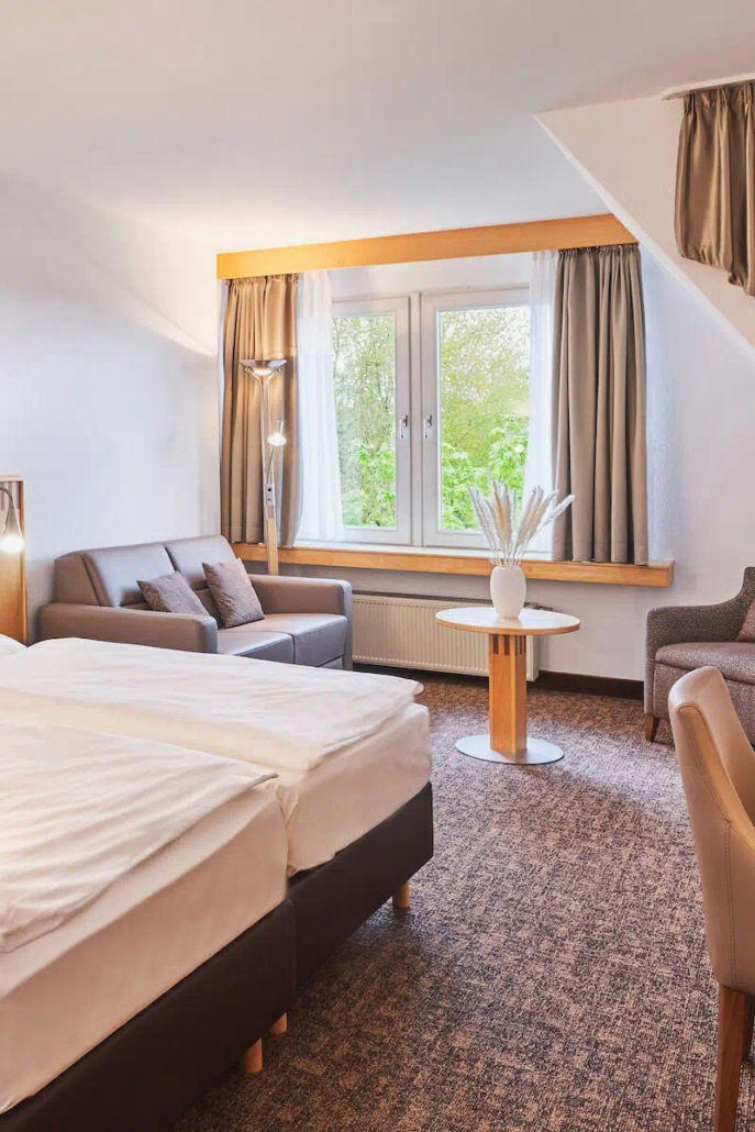 Helles Doppelzimmer mit großem Fenster und Blick ins Grüne