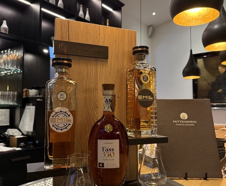 Auswahl an Spirituosenflaschen auf einer Holztheke.